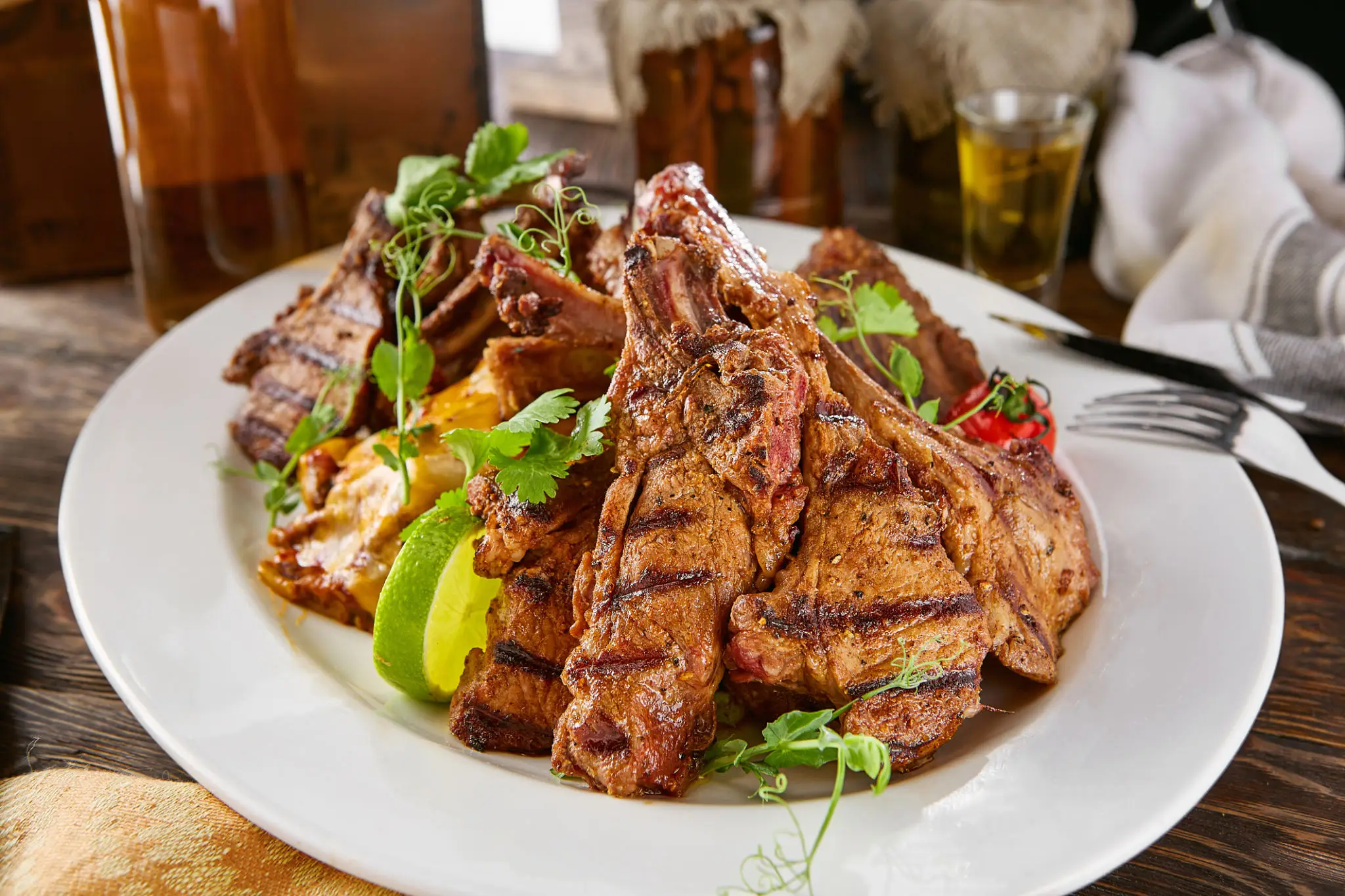 Grilled lamb chops served with vegetables and herbs.