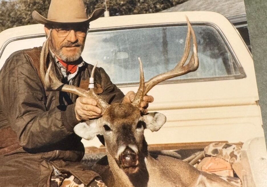 A man posing with a deer he hunted.